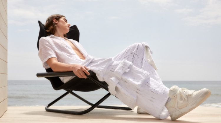 Maxim Emanuel wears a monochromatic white look for AMIRI's pre-fall 2023 campaign.