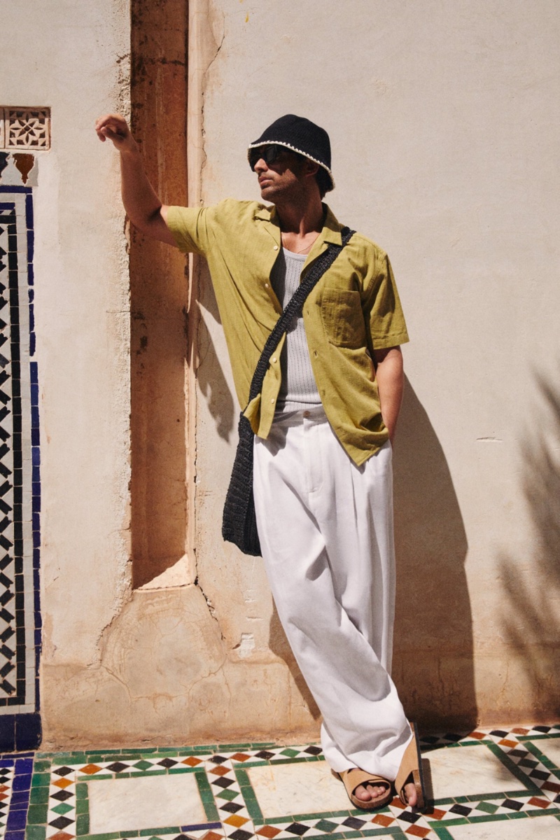 Zara enlists Andrew Georgiades for a Moroccan excursion, where he sports a crochet tank top, textured geometric shirt, linen pants, and two strap suede sandals.