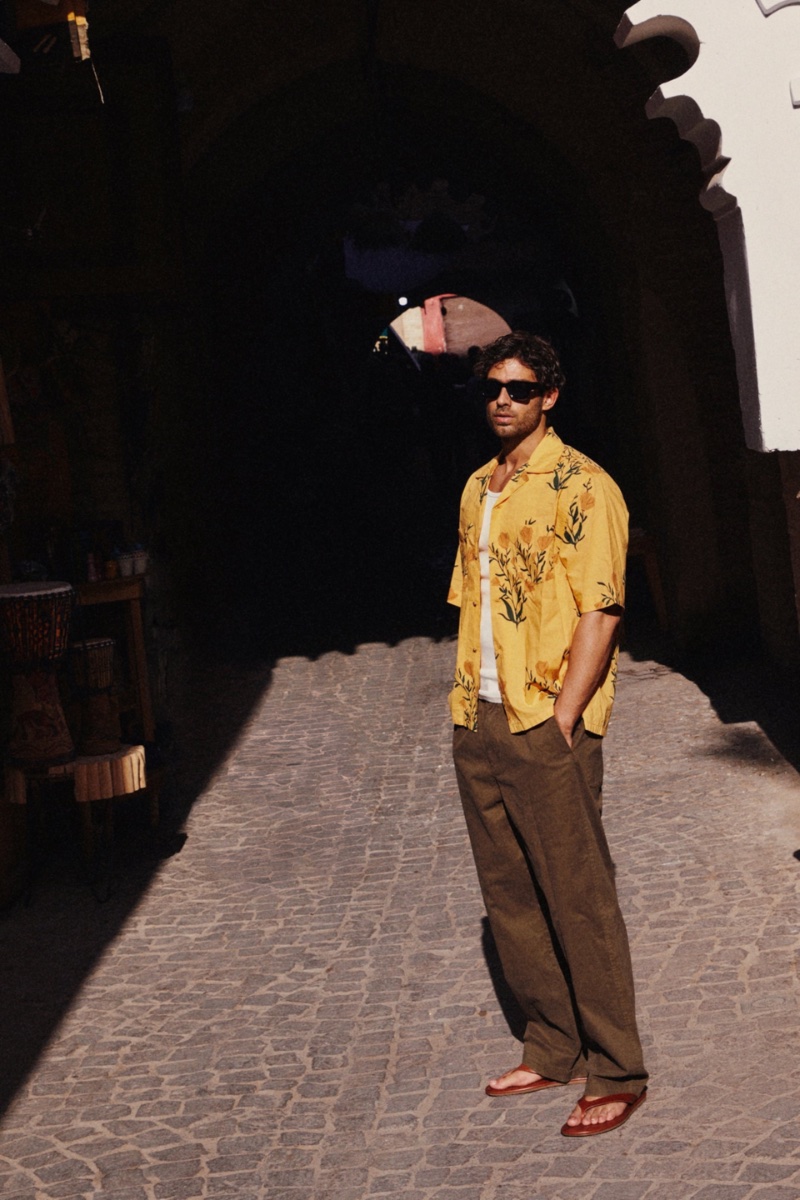 Taking to the streets of Marrakesh, Morocco, Andrew Georgiades wears Zara's floral print shirt over a crochet tank top with straight fit pants and leather sandals.