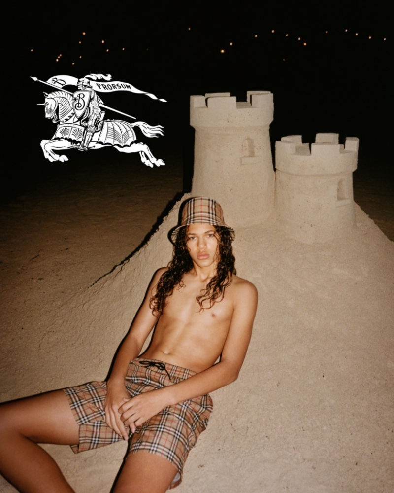 Kaedon Baxter sports a check bucket hat and drawcord swim shorts for Burberry's summer 2023 campaign.
