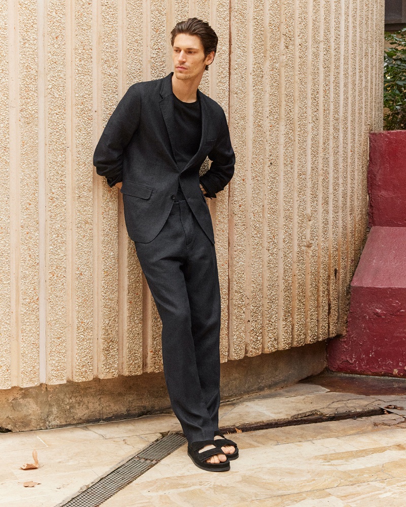 Wearing all-black, Justin Eric Martin dons an unstructured linen suit with a t-shirt.