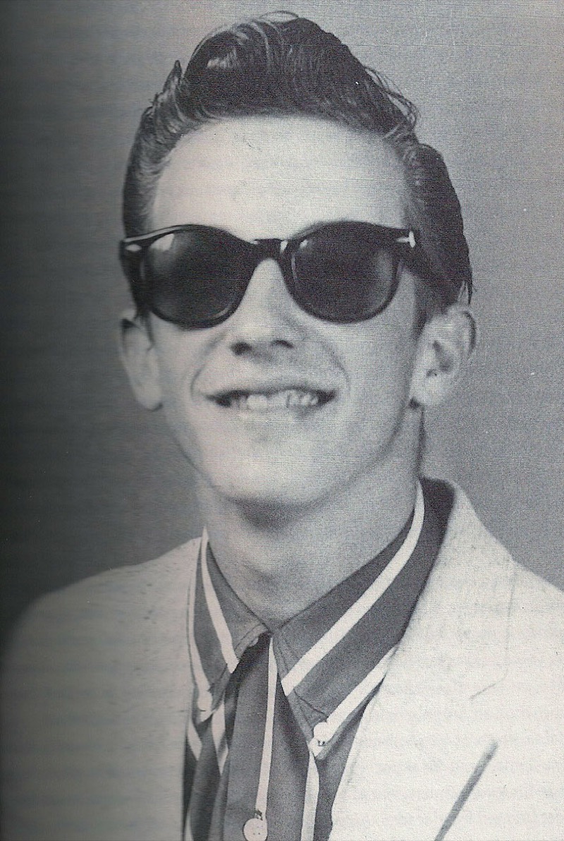 Doug Sahm channels rockabilly style, sporting a greased-back ducktail and Wayfarer-style sunglasses.