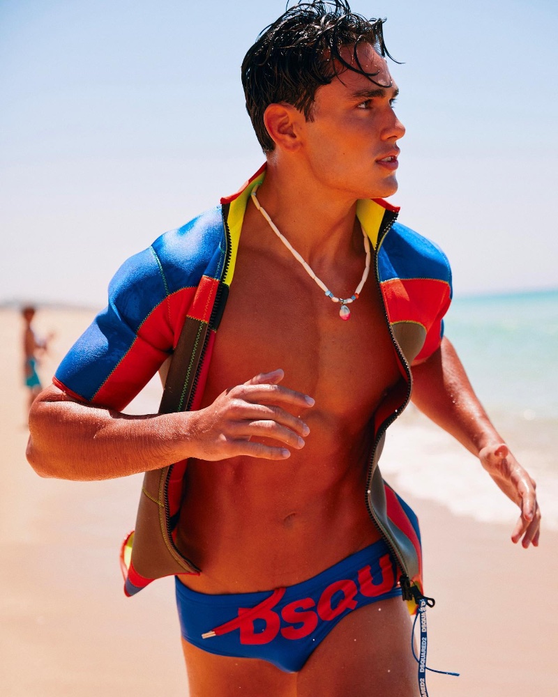 Giorgio Ramondetta hits the beach in a blue swim brief for Dsquared2's summer 2023 beachwear campaign.