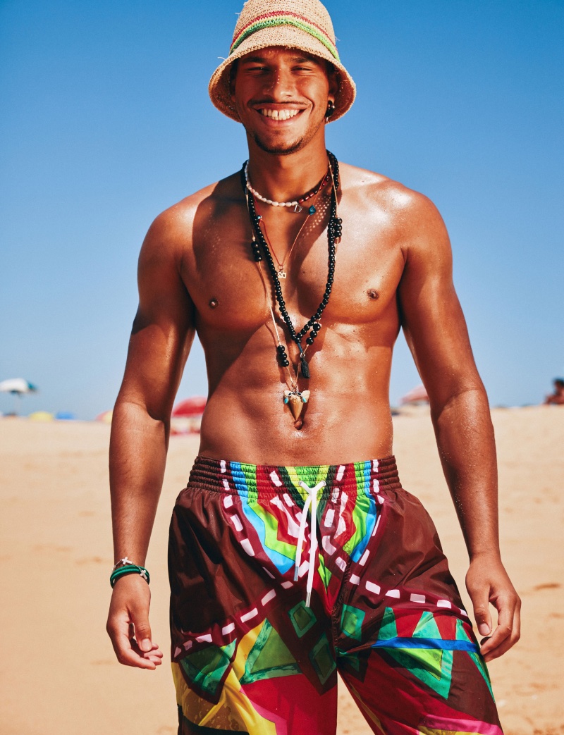 Reuniting with Dsquared2 for the summer, Tyler Andre is all smiles once more in a graphic pair of swim shorts for the brand's summer 2023 beachwear campaign.