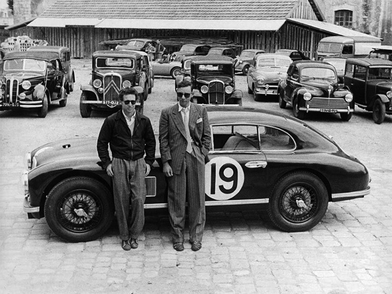 Race car drivers George Abecassis and Lance Macklin pose for photos at Le Mans in 1950.