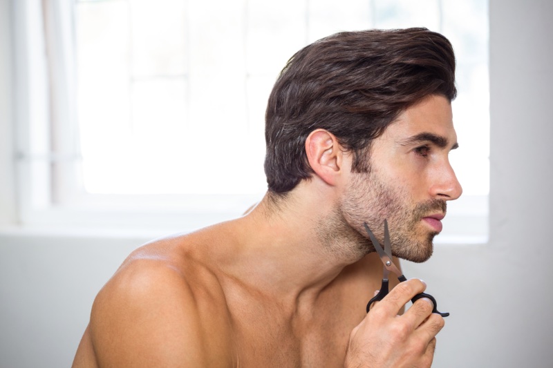 Man Using Scissors on Beard