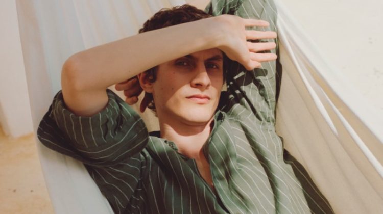 Lounging, Henry Kitcher dons a striped Massimo Dutti shirt.