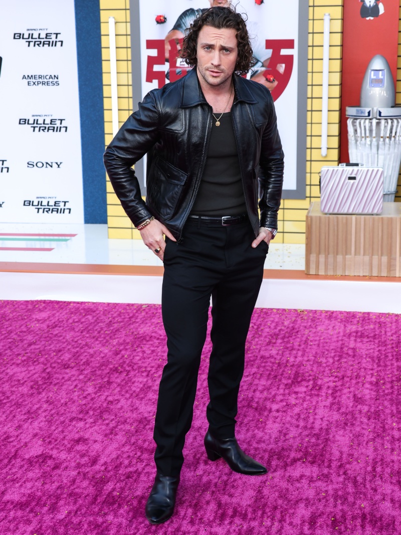Aaron Taylor-Johnson wears all black, including a leather jacket, to attend the Los Angeles premiere of Bullet Train. 