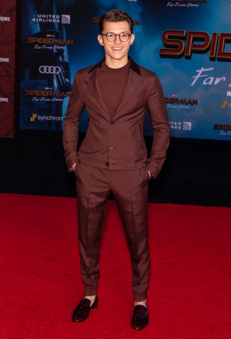 Donning a single color outfit, Tom Holland broke with convention in a burgundy Ermenegildo Zegna jogging suit and matching shirt to attend the Los Angeles premiere of Spider-Man: Far from Home.