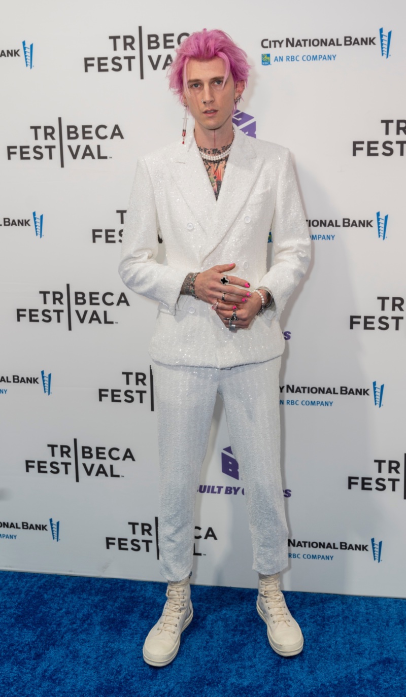 Stepping out in formal wear, Machine Gun Kelly makes a sartorial splash in a white double-breasted suit by Dolce & Gabbana. Attending the New York premiere of Taurus, MGK accessorized with pearls and high tops. Meanwhile his pink hair added a nice contrast.