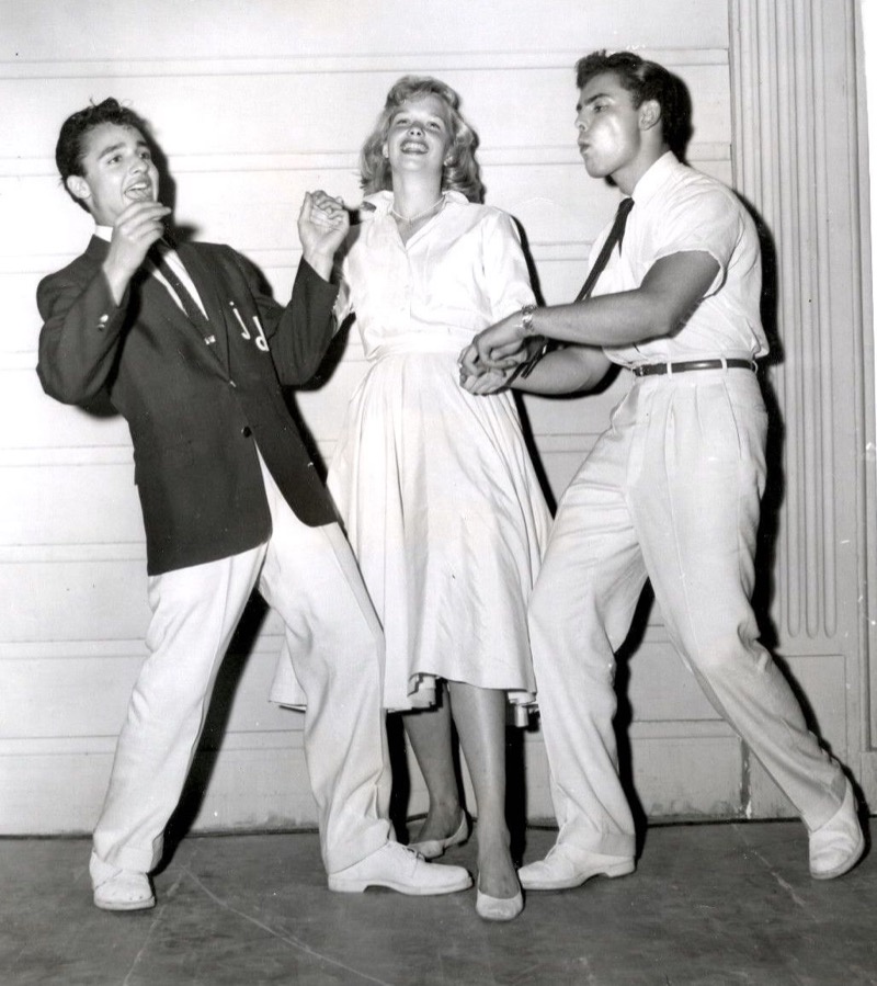 Sal Mineo and John Saxon cut loose in classic '50s teen style for Rock, Pretty Baby. They wear pleated high-waist trousers and enough Brylcreem to survive a sock hop, while Sue George holds her own.