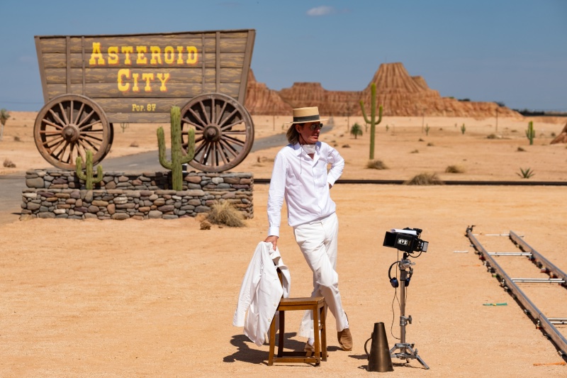 Director Wes Anderson captured on the set of Asteroid City in an all-white outfit and straw boater hat.