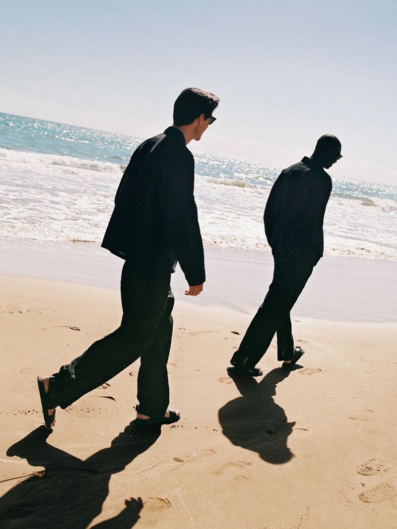 Models Jonas Mason and Fernando Cabral take to the beach in sleek summer looks in black by ARKET. 