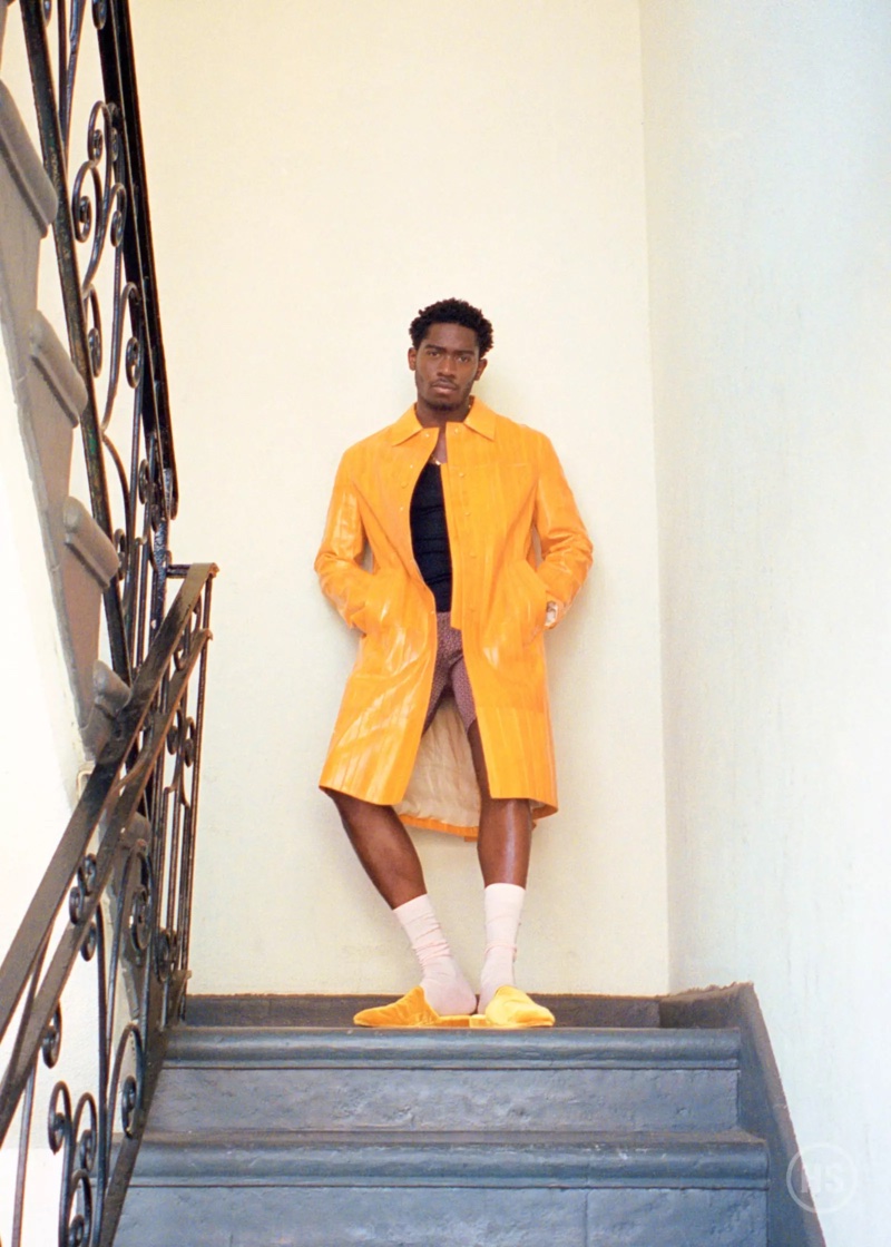 Damson Idris wears a Calvin Klein top with Luar shorts, a yellow Lanvin coat, and Lenys World slippers.