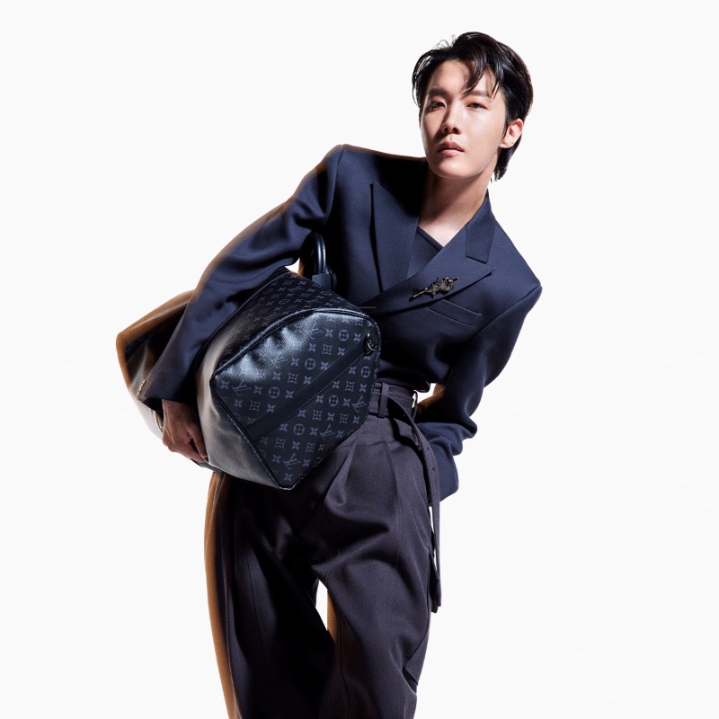 Louis Vuitton house ambassador J-Hope sports navy tailoring as he poses with a Monogram Eclipse keepall for the brand's newest campaign.