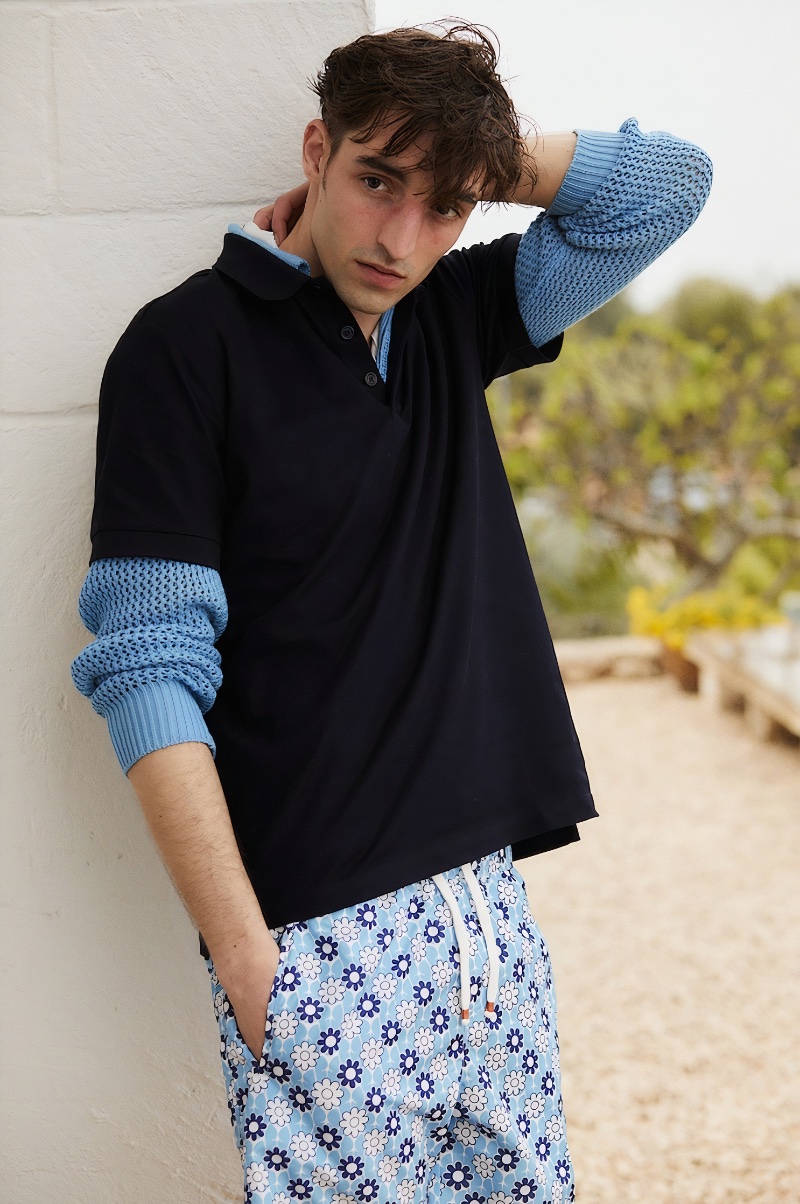 Layering, Luca Jamal wears a Burberry cotton pique polo over a sweater with Sam Diego daisy print swim shorts. 