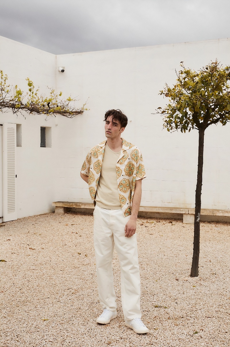 Mixing neutral tones, Luca Jamal rocks a Commas camp collar shirt with a Nanushka tank, Carhartt WIP pants, and Golden Goose sneakers. 