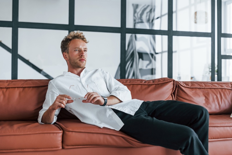 Man Relaxing on Leather Couch