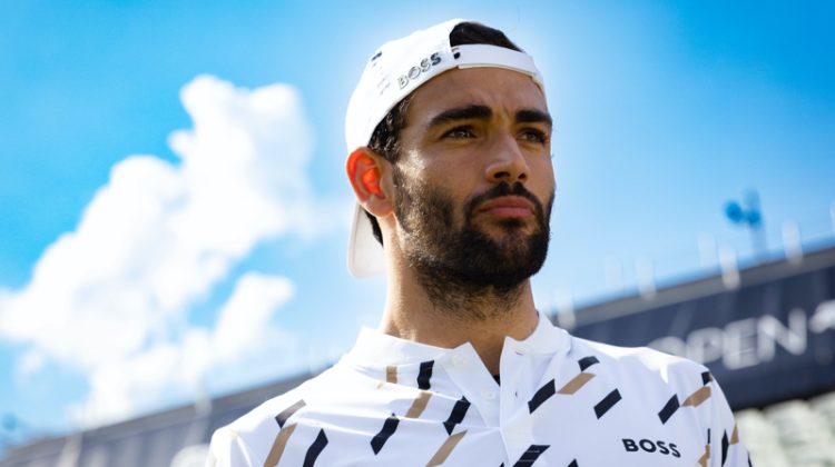 Sporting a backward cap, Matteo Berrettini showcases a houndstooth polo shirt from his BOSS capsule collection.