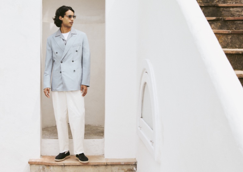 Matteo Tagliabue wears a Brioni double-breasted jacket, t-shirt, Cuban shirt, and silk trousers with Brunello Cucinelli sunglasses and Officine Creative shoes.