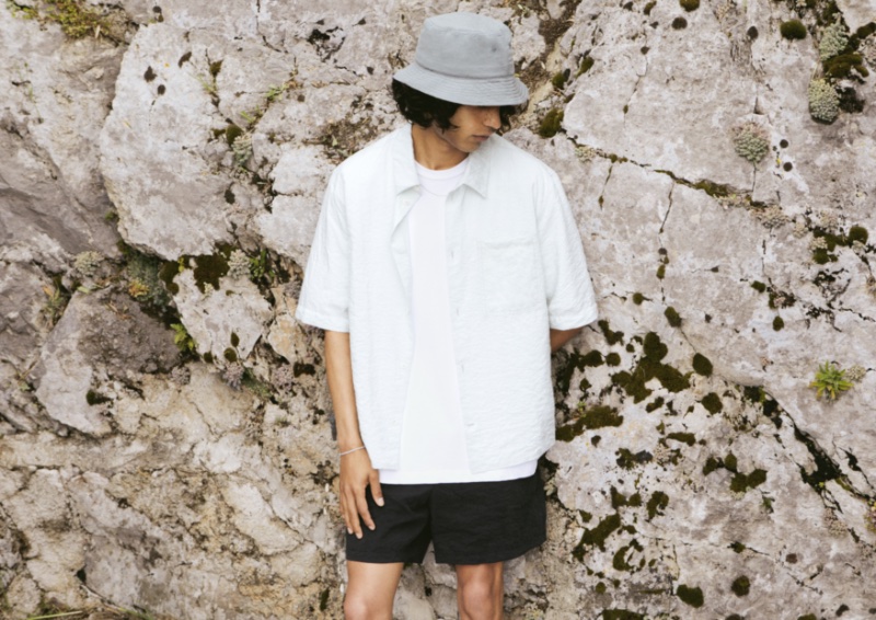 A casual vision, Matteo Tagliabue rocks a t-shirt, shirt, shorts, and bucket hat by SSAM. 