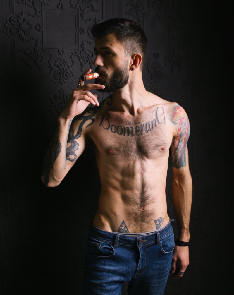 Vertical shot of a young European tattooed hip male in white shorts and  shirt and a metal chain Stock Photo  Alamy