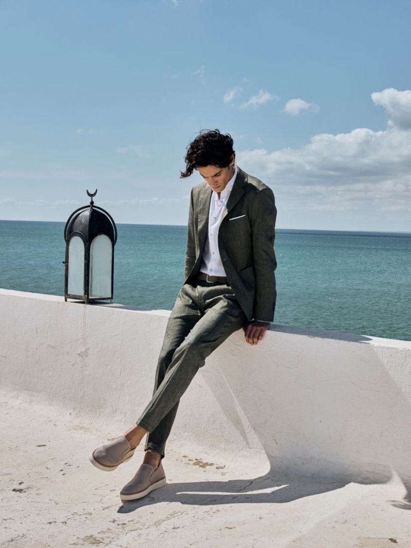 A sleek vision, Federico Novello wears a linen suit with a crisp white shirt and slip-on sneakers.
