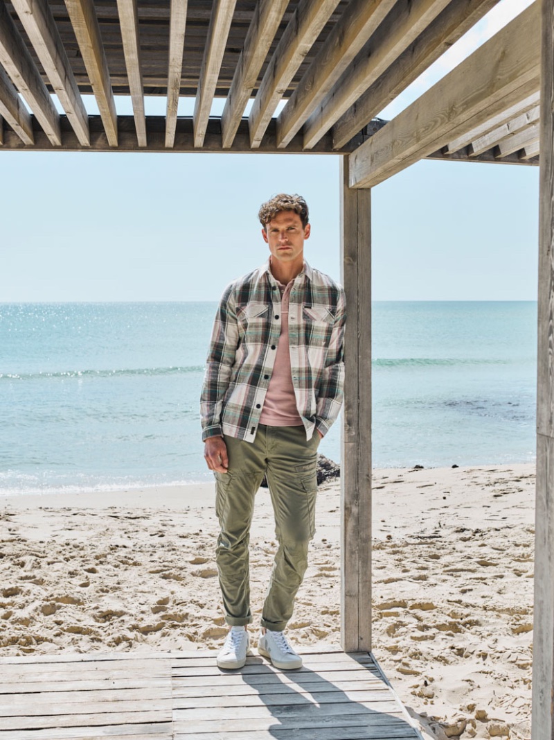 Guy Robinson sports a plaid long-sleeve shirt with trendy cargo pants.