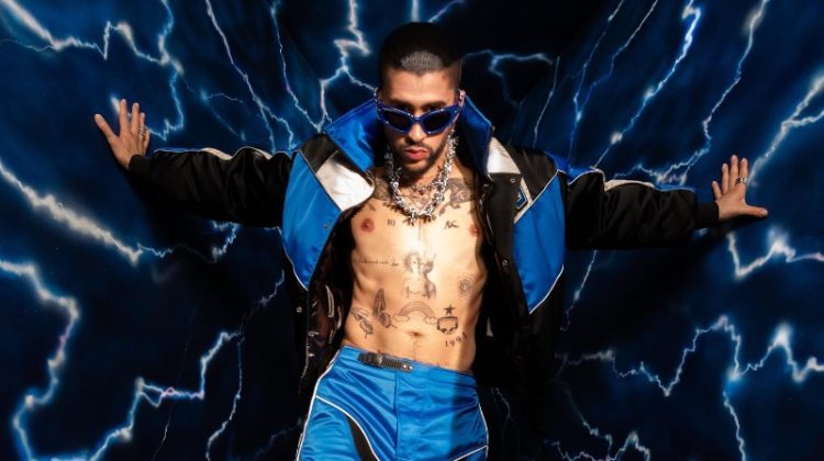 Making an electric statement, Bad Bunny rocks a Heliot Emil jacket and pants with Gentle Monster Paso BL3 sunglasses. He also sports Louis Vuitton shoes and Apt.1007 necklaces.