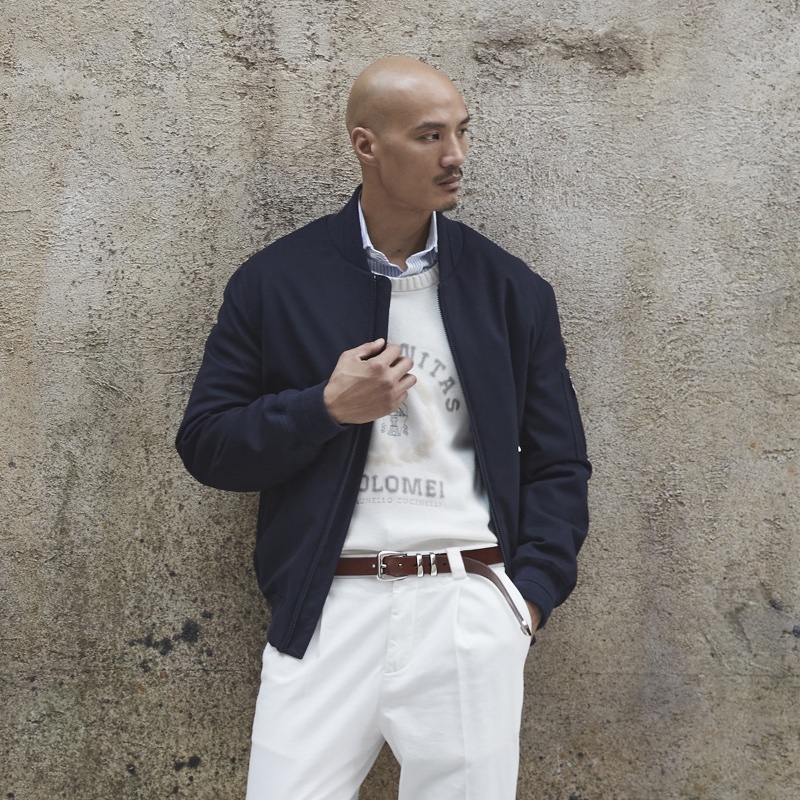 Paolo Roldan makes a case for navy and white as he sports a Brunello Cucinelli bomber jacket with pleated trousers and a printed crewneck sweater.