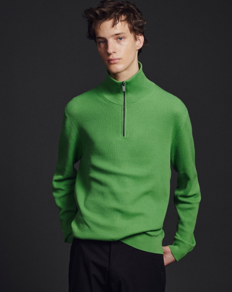 Making a colorful statement, Joshua Thompson dons a green mock neck sweater by Massimo Dutti.