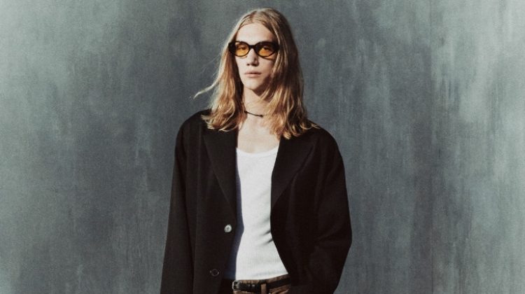 Valentyn Boiko wears a wool coat with waxed effect jeans, square toe leather Chelsea boots, and oval sunglasses from the Zara Edition pre-fall 2023 collection.