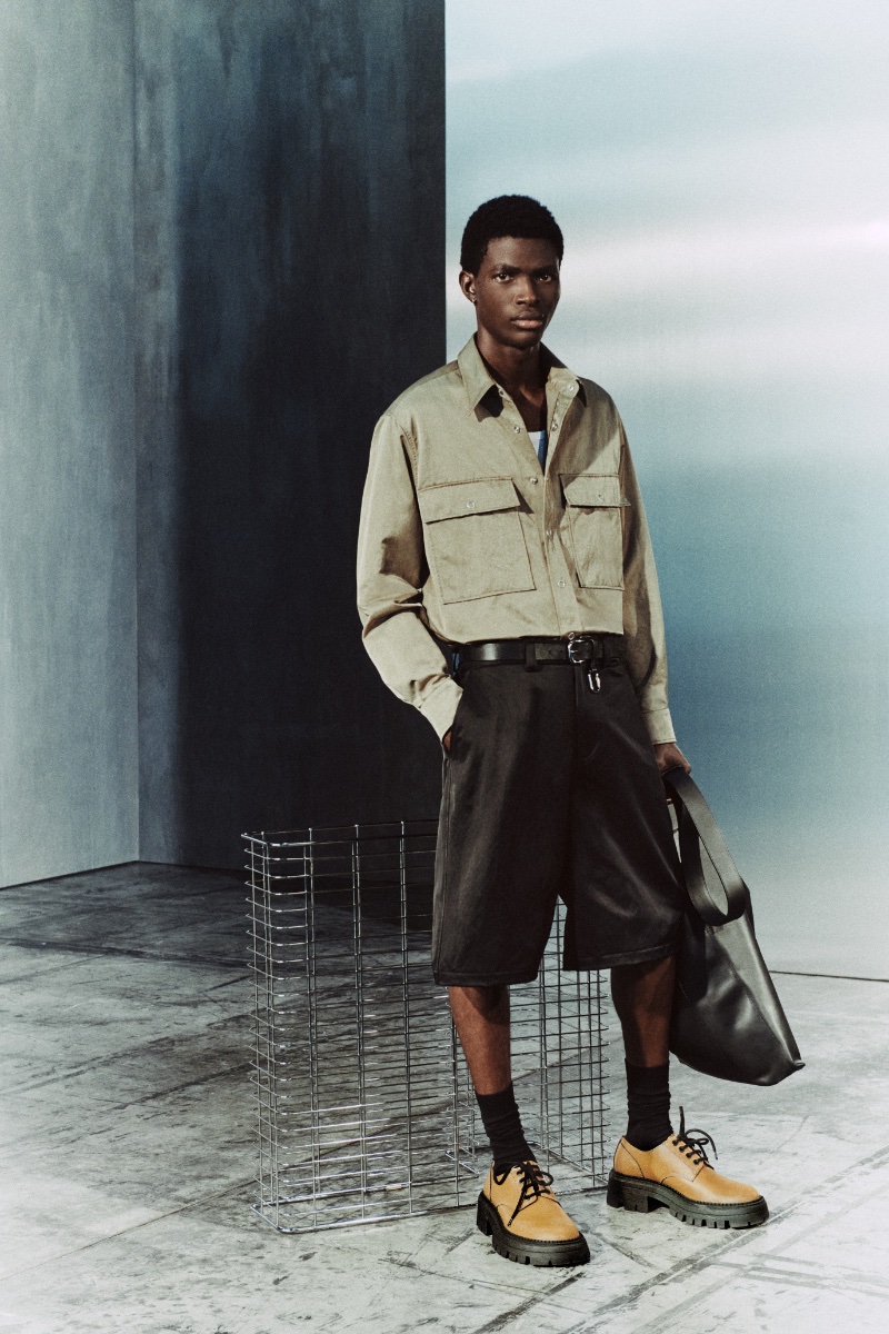 John Godswill dons a technical shirt and shorts with chunky derby shoes from the Zara Edition fall 2023 collection. 