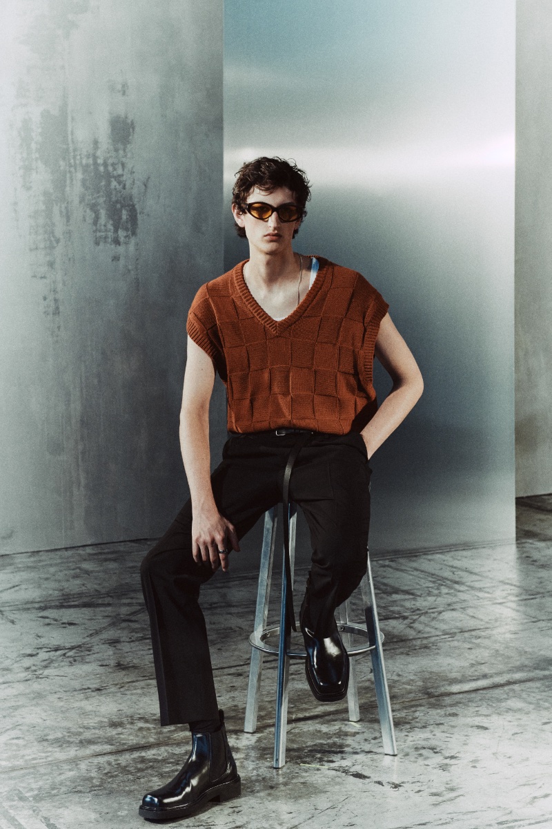 Anden Scudder wears a knit vest with wool trousers and square toe leather Chelsea boots from the Zara Edition fall 2023 collection. 