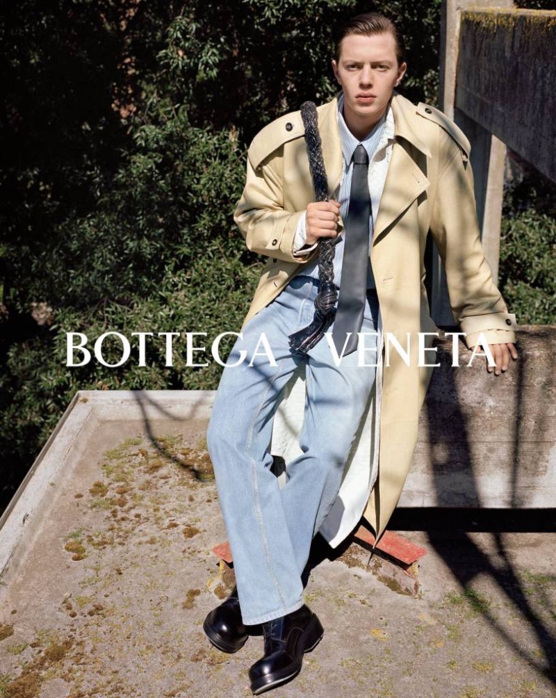 Silas de Maat wears a trench and jeans for Bottega Veneta's fall-winter 2023 campaign.