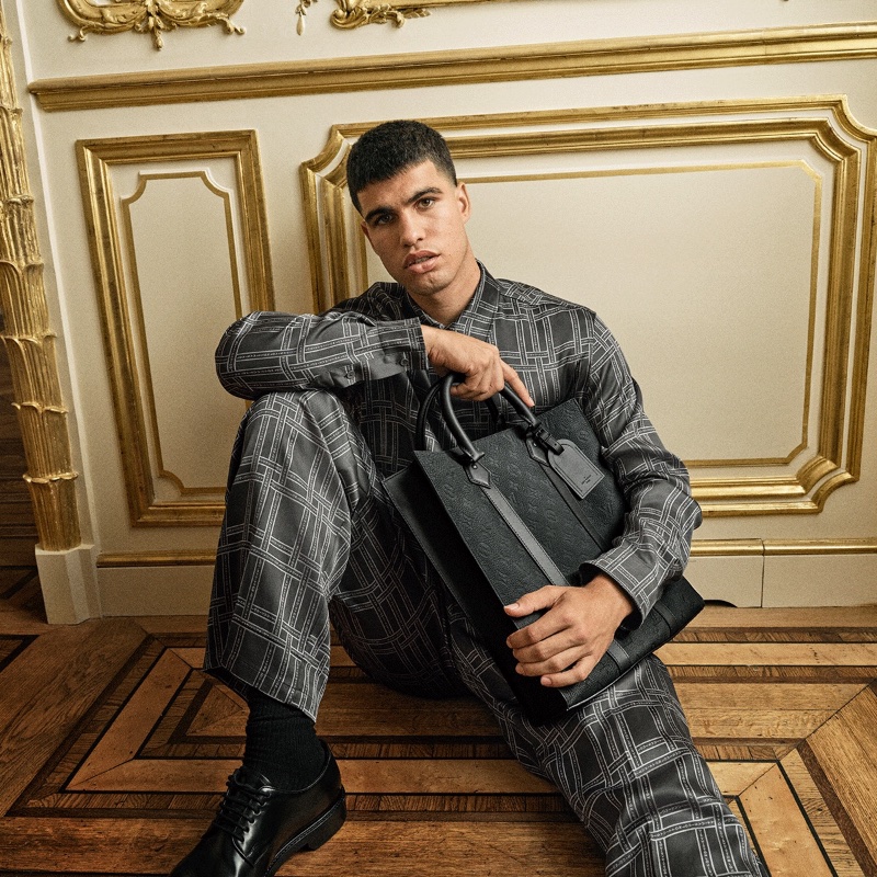 Sporting a graphic ensembles, Carlos Alcaraz poses with the Georges tote for the Louis Vuitton New Formal collection campaign. » Carlos Alcaraz for Louis Vuitton Campaign: The New Formal Sporting a graphic ensembles, Carlos Alcaraz poses with the Georges tote for the Louis Vuitton New Formal collection campaign.