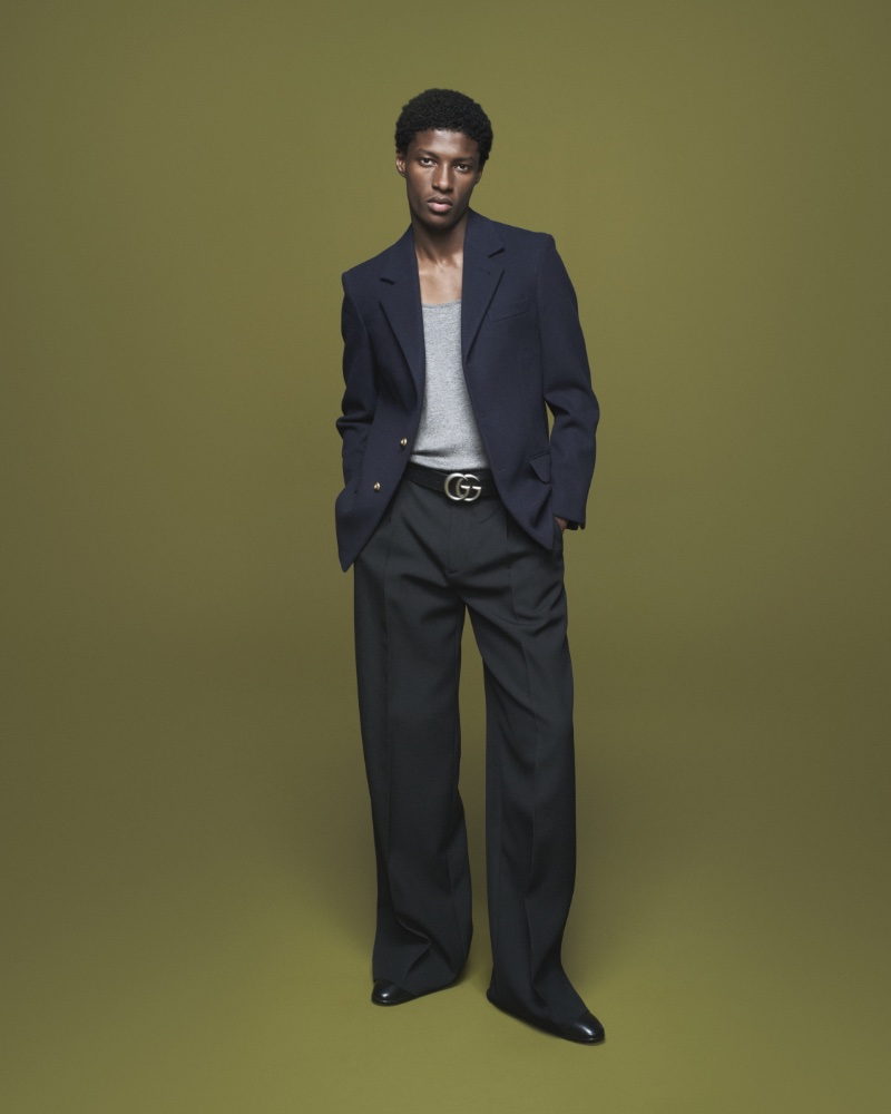 Donning flared trousers with a navy blazer, Aboubakar Konte fronts Gucci's fall-winter 2023 campaign.