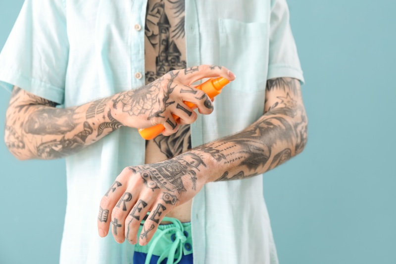 Man with Tattoos Sunscreen Closeup Crop