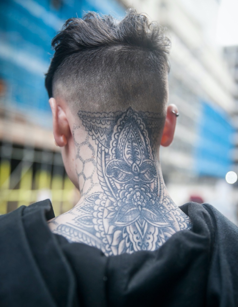 Close-up of neck tattoo on man against colored background stock photo