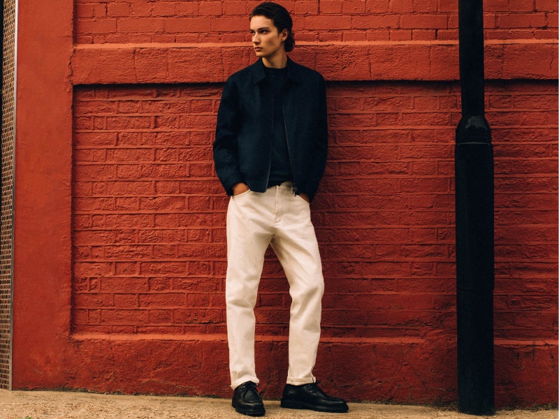 Model Dante Scheck steps out in a cotton-blend zip-up jacket with a relaxed-fit short-sleeve cotton t-shirt and straight-fit selvedge jeans from the fall-winter 2023 Massimo Dutti Studio collection. 