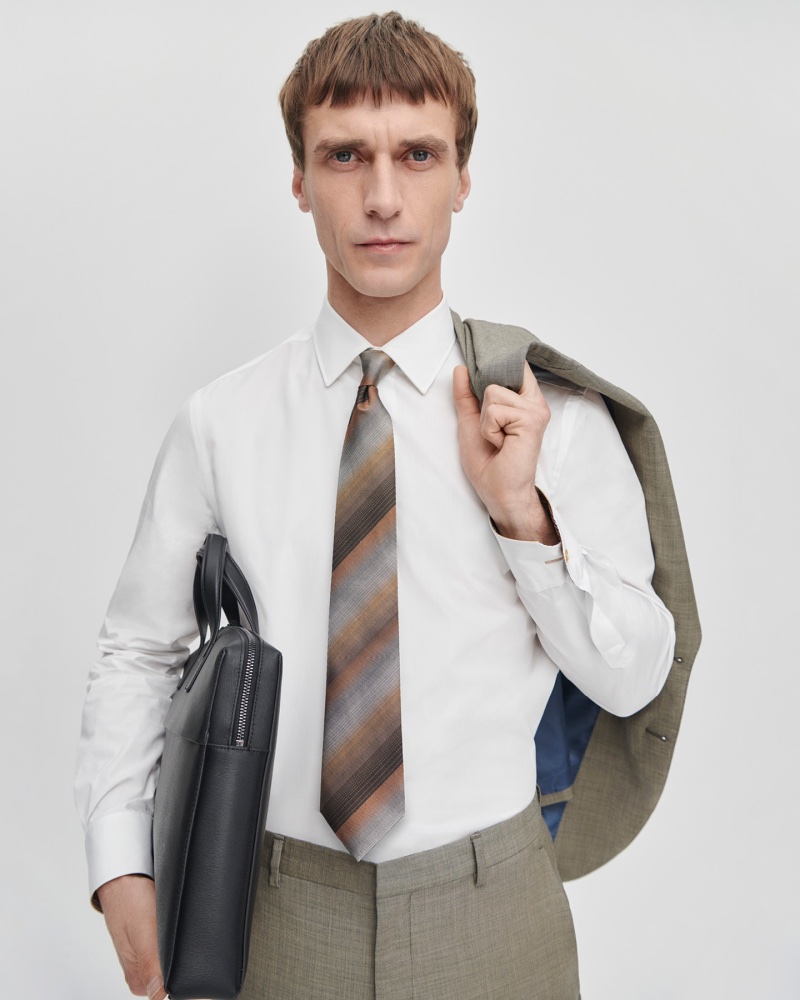 Dressed for business, Clément Chabernaud wears The Kensington grey and brown mini check wool suit with a brown silk ombre stripe tie by Paul Smith.