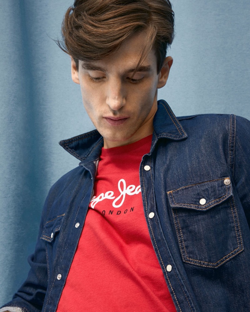 Wearing a red Pepe Jeans t-shirt, Anatol Modzelewski also sports a classic indigo blue snap button denim shirt. 