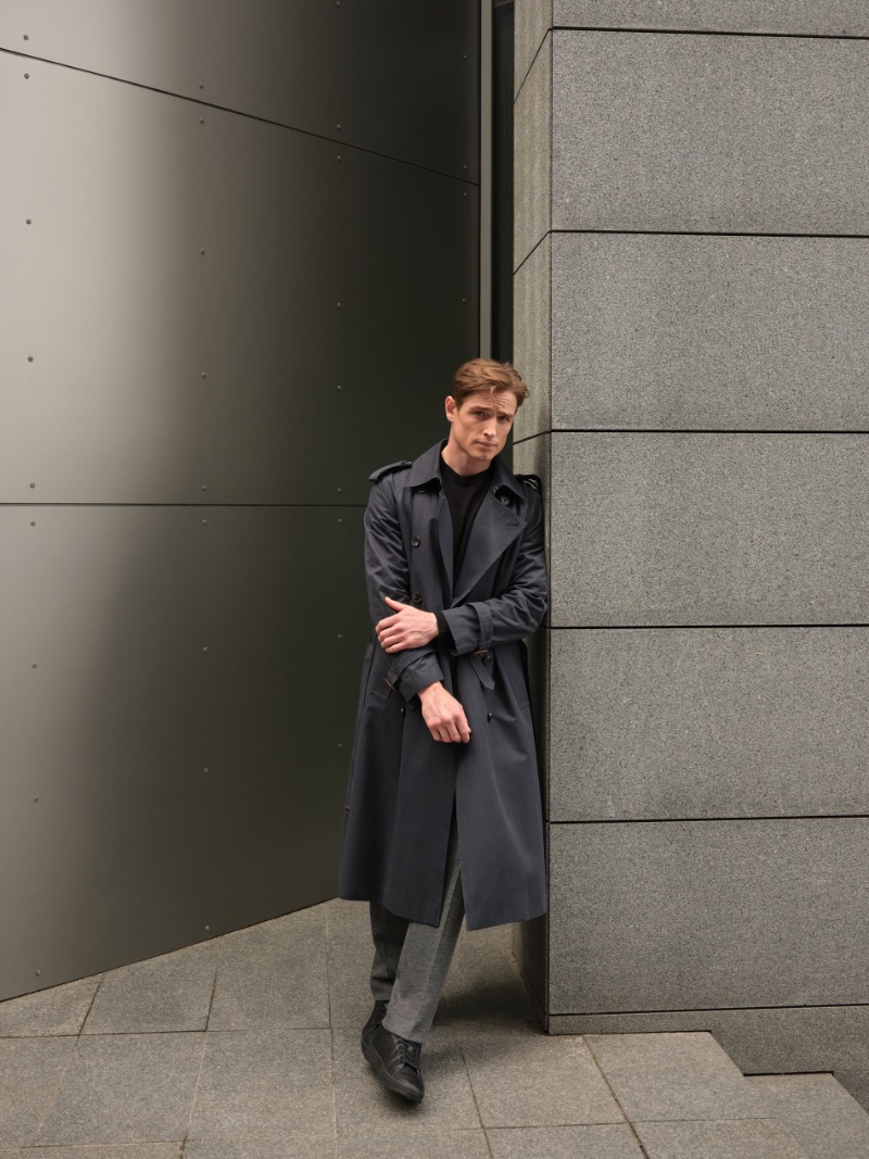 Embracing professional style, Patrick O'Donnell rocks a Reserved double-breasted trench with a merino wool sweater and suit trousers.