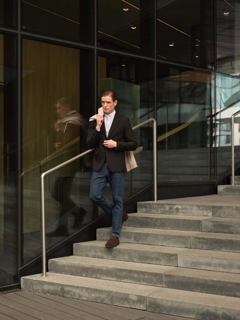 Showcasing business casual style from Reserved, Patrick O'Donnell wears a blazer with a slim-fit shirt and jeans. 