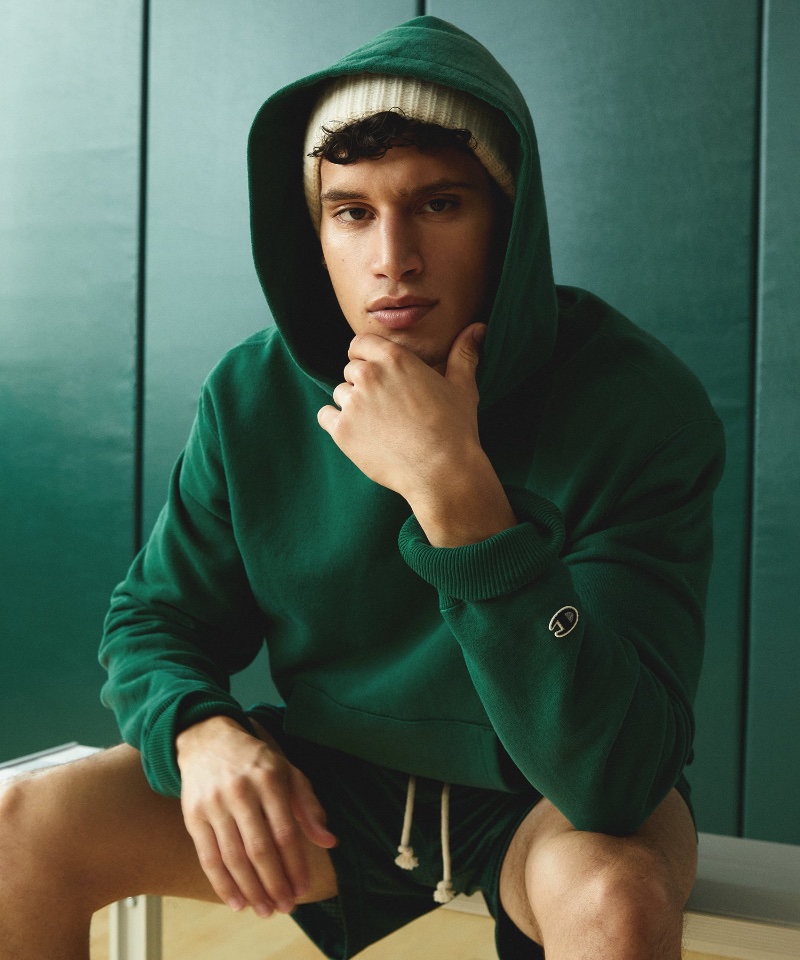 Alexis Chaparro models a relaxed hoodie and mesh shorts in green from the Todd Snyder + Champion fall-winter 2023 collection. 