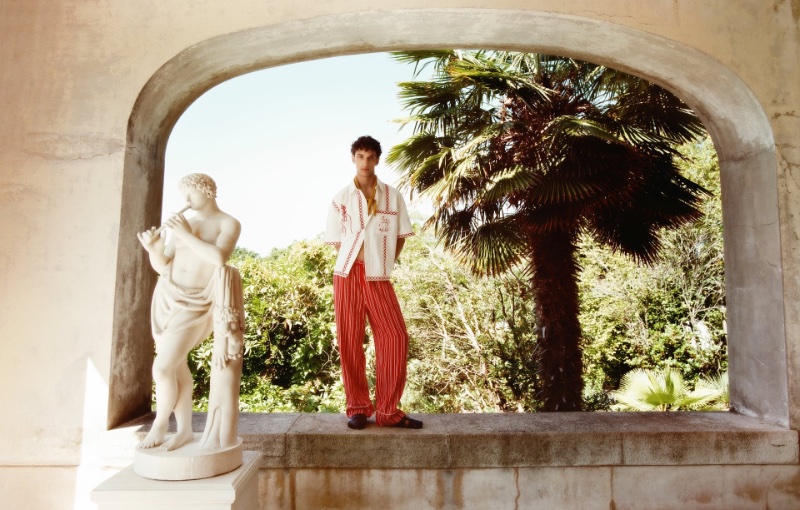 Habib Masovic wears an embroidered shirt with linen striped pants and leather sandals from Zara's summer 2023 capsule collection. 