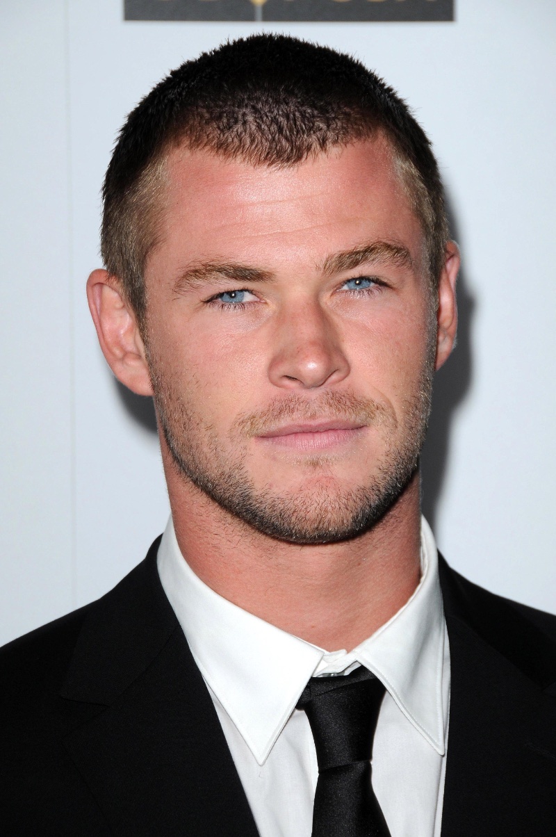 Chris Hemsworth goes minimal with a buzz cut, showcasing a rugged edge.