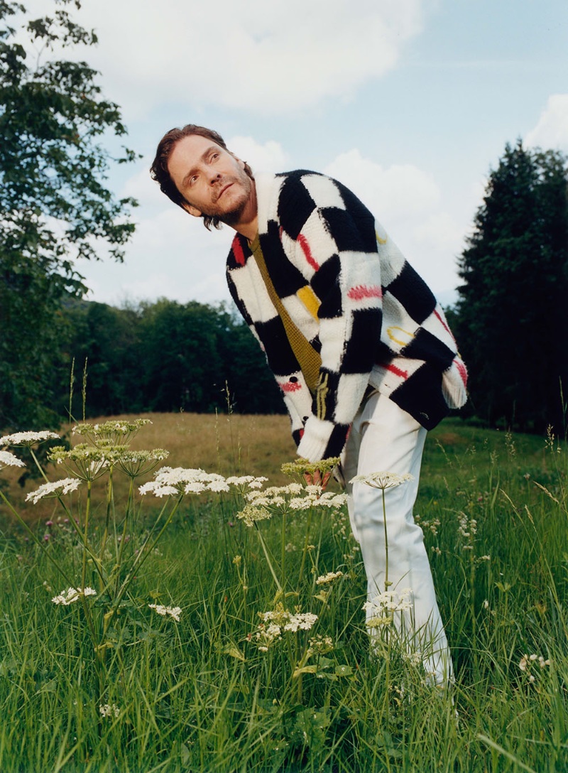 Stepping out in a graphic cardigan, Daniel Brühl stars in the Zegna x The Elder Statesman fall-winter 2023 campaign.