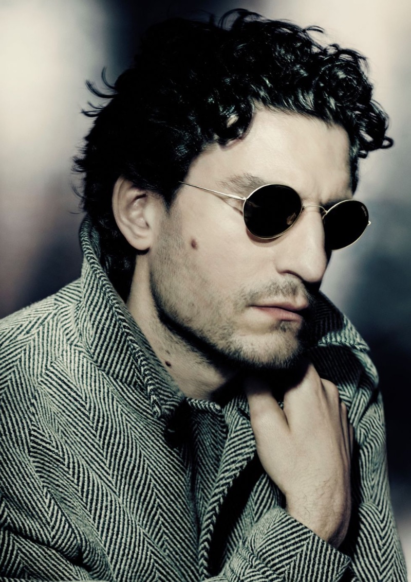 Rocking round sunglasses and a herringbone coat, Louis Garrel fronts Giorgio Armani's fall-winter 2023 campaign.