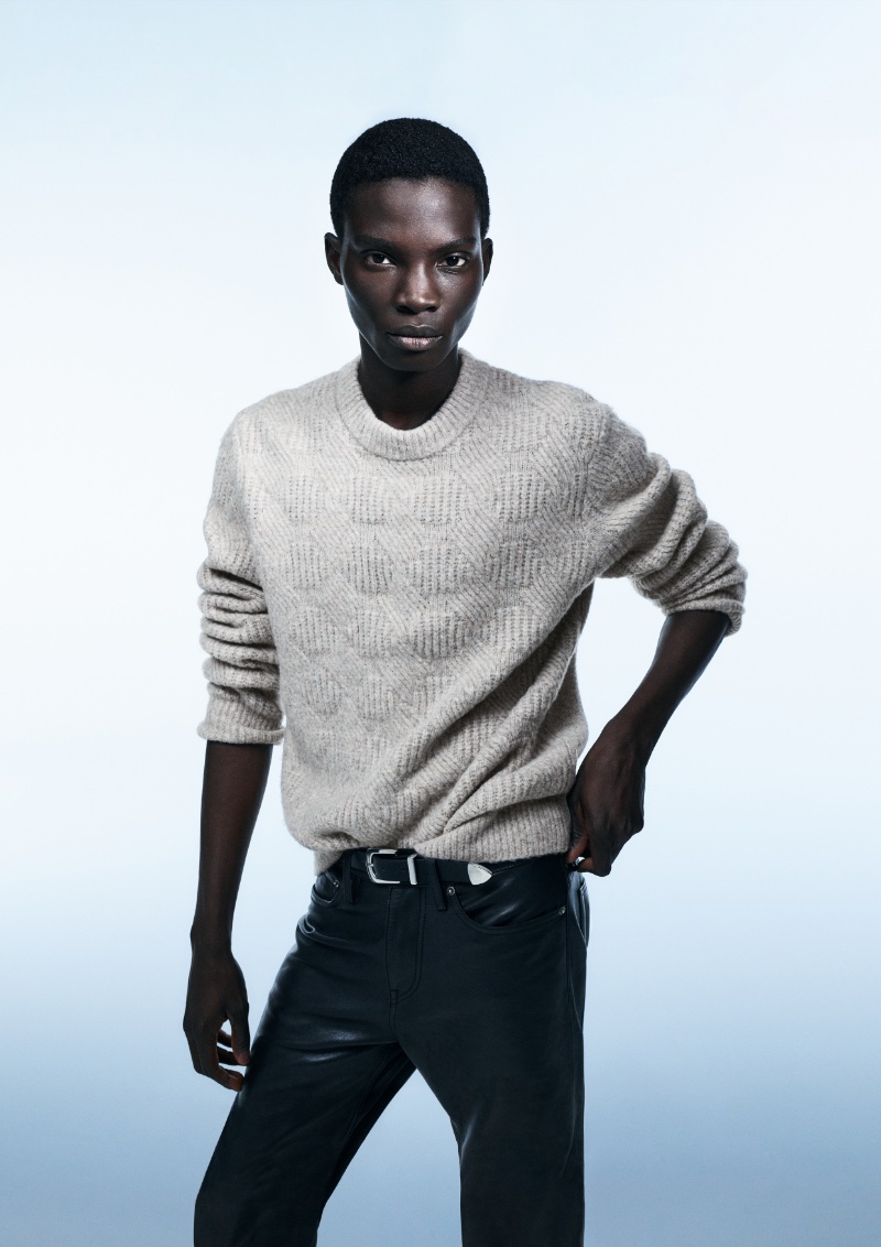 Dara Gueye dons a crewneck sweater with leather pants for H&M's fall-winter 2023 campaign. 